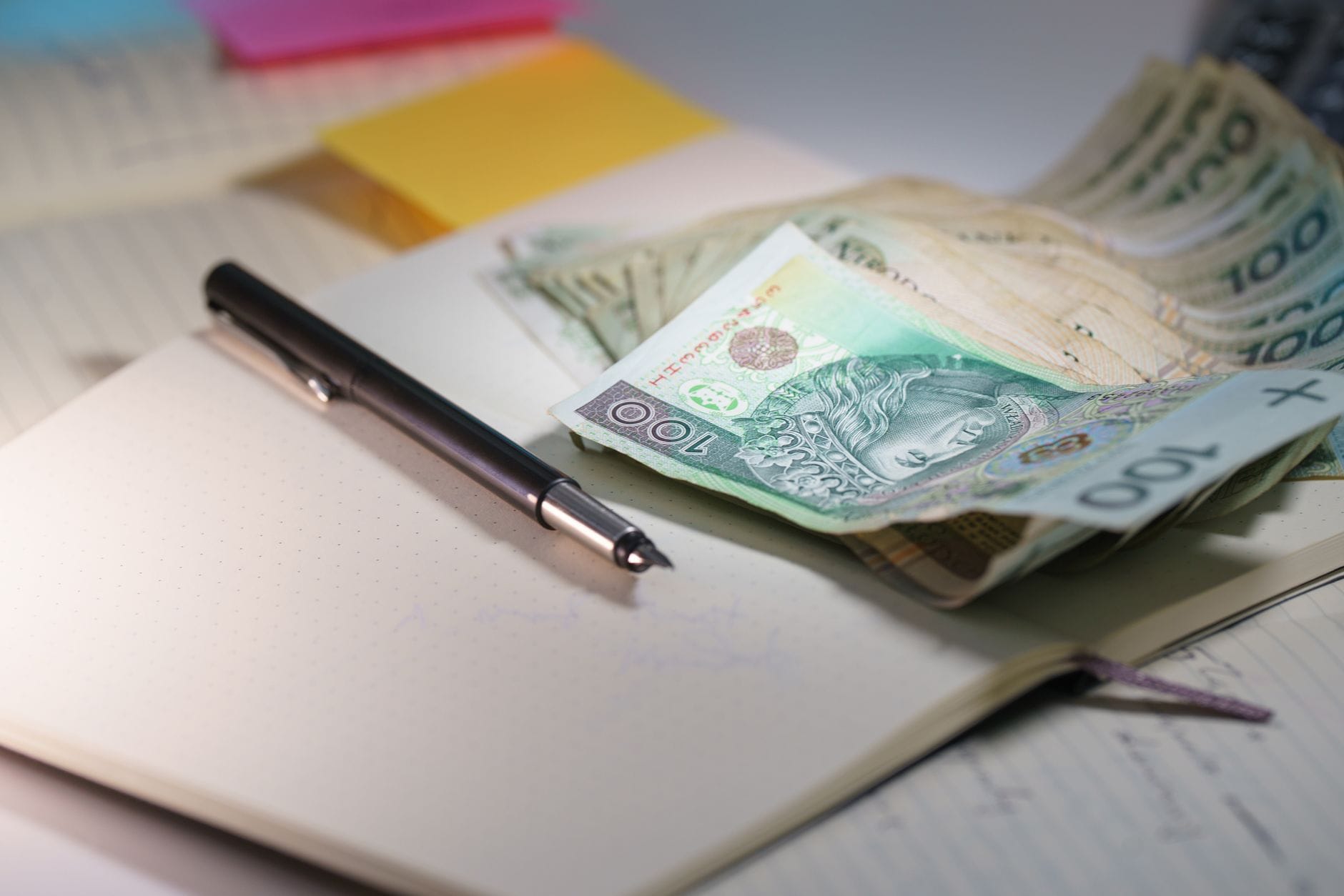 Banknoty i dokumenty finansowe podczas analizy kredytu gotówkowego oraz pożyczki pozabankowej