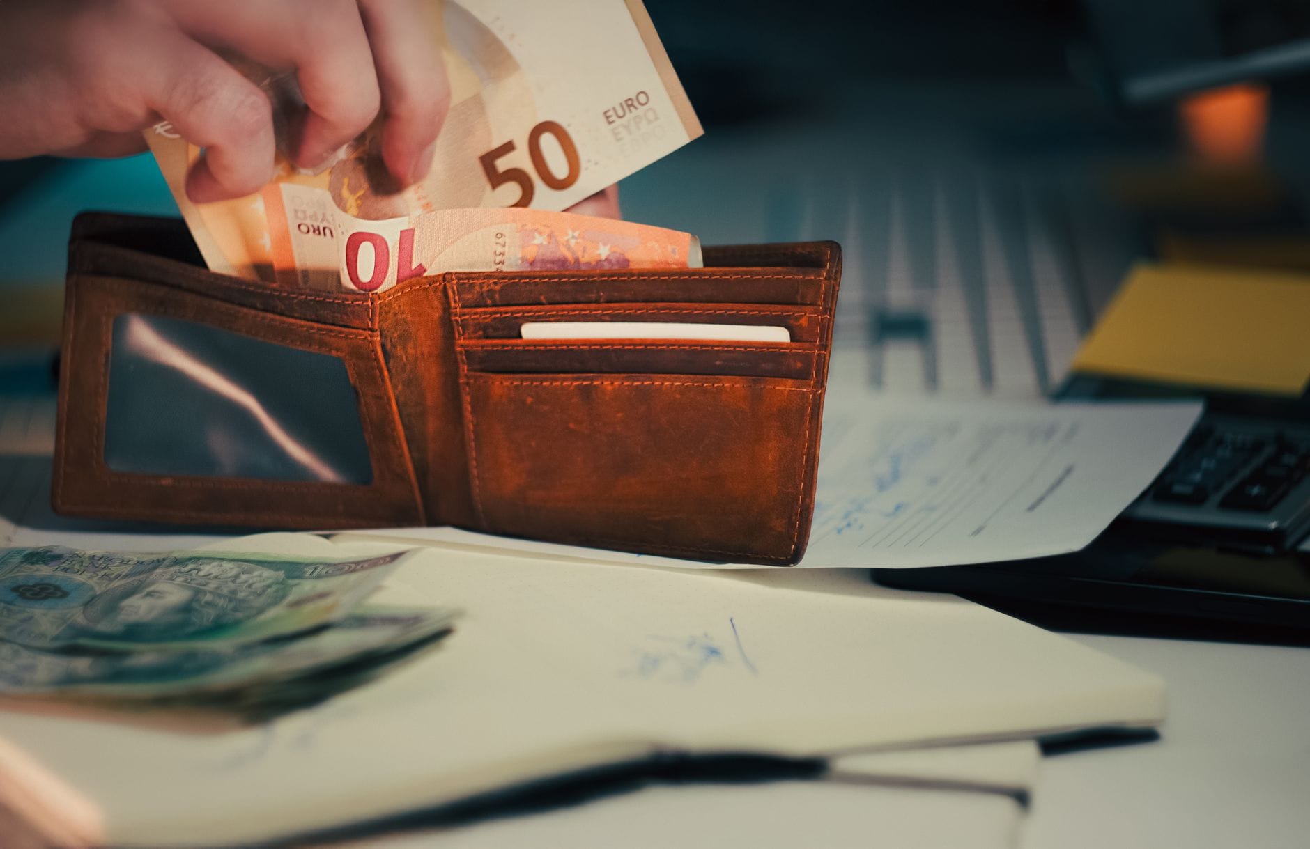 Portfel z banknotami euro i dokumentami na biurku w biurze