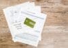Chargeback w banku: kiedy można odzyskać pieniądze za płatność kartą? Karta kredytowa i dokumenty wniosku na drewnianym blacie